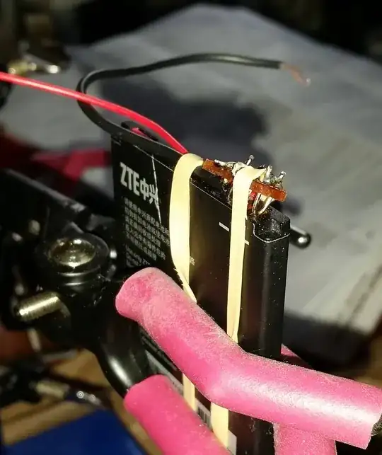 Metal wire in stripboard creates contacts for mobile phone battery