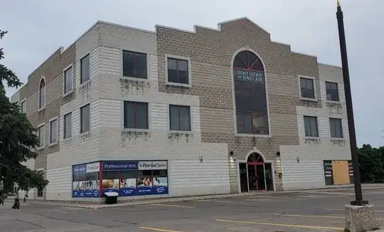 a building with dark patches on its brick exterior under every window