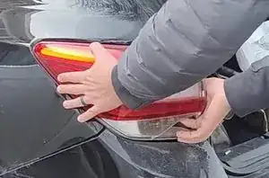 Tap the tail light assembly and pull it from the side to remove it from the vehicle.