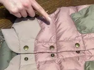 Locate the feather that's poking out of the fabric.