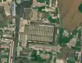 2/7 Public market (amenity=marketplace) with many stalls crossed by a long axis in front of the entrance on the left along the road (Maxar satellite imagery).