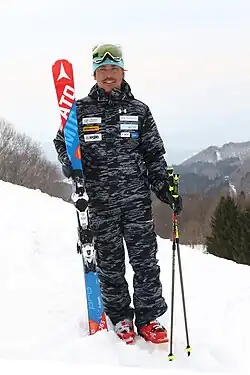 Photo of Kentaro Minagawa on a snowy hill with skiing equipment.