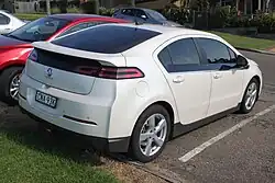 Slightly sloped three-quarters front view image of a white liftback with Holden badging and short suspension.