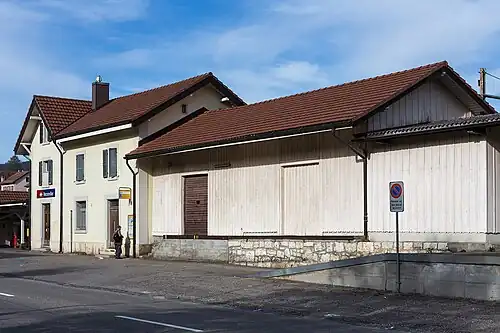 Two-story building with gabled roof and adjoining freight house