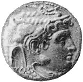 A black and white photograph of the front of a silver coin, showing a long-haired man