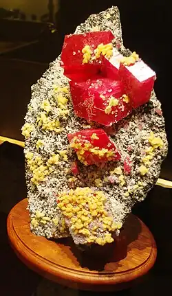 Lump of brown rock with red rectangular crystals protruding out