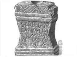 A black and white drawing of a stone block with a Latin inscription.