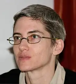 Head shot of Amalia Ziv. Very short graying hair. Looking to the side of the camera.