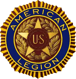 Five-pointed star with the insignia "U.S." enclosed in two bronze bands in the star's center. This design is enclosed in a wreath. Encircling the star and the wreath are the words "American Legion" set in deep blue enamel. This, in turn, is encircled by a narrow band suggestive of the rays of the sun