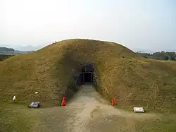Grass covered hillock with an entrance.