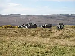 photo of armoured vehicles easy to see on bare hillside