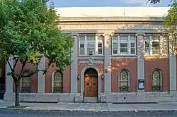 Front view of building, five bays wide. The windows are stained glass showing Jewish motifs such as six-pointed stars.