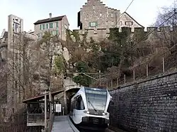 The railway station, train of the S33 line (formerly operated by Thurbo), tunnel and castle seen from the station platform