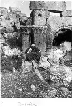 Kurdish man in front of the church apse. Twisted column, Corinthian capital.