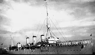 A warship at sea under a bright sky, possibly underway
