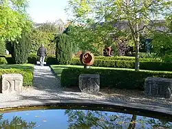 Ornamental garden with stone blocks with incised lettering around the edge of a pond