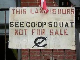Sign that says "THIS LAND IS OURS. SEE CO-OP SQUAT. NOT FOR SALE."