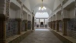 Hallway lined by pillars decorated with patterned tiles