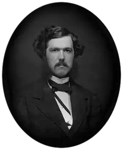 Black-and-white photograph of a young man with a mustache