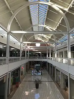 A two-level mall corridor with a rounded truss.