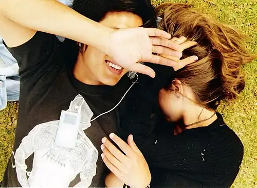 A couple listening to music together on an iPod Mini (2006)