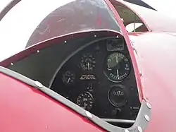 this image shows very simple basic instrumentation in one of the de havilland moth minor's two cockpits. it is low definition and rather blurry.