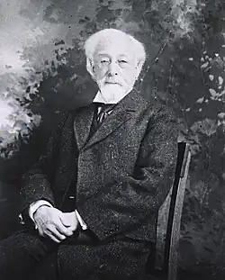 Three-quarter length, seated in chair, front pose, tweed suit, very old man