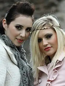 Image 117Two women in England, the woman on the left wears a pompadour, while the woman on the right sports side-parted blonde hair with a boho-style headband, 2011. (from 2010s in fashion)