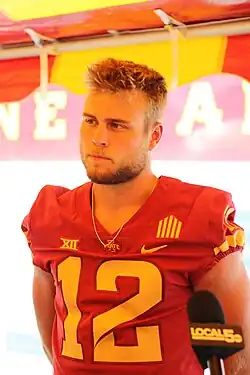 Hunter Dekkers, wearing a red jersey with a yellow number 12 on it, speaks to the press during Iowa State's media day in 2022.