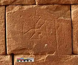 Graffito in the form a cross carved into a brick.