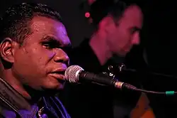 A black man singing into a mircophone