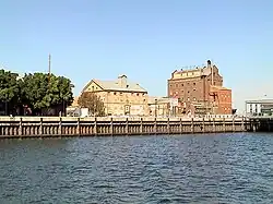 Hart's Mill (1855, centre) and the Adelaide Milling Company flour mill (c.1890, right) are prominent landmarks adjacent to the southern wharf of the Inner Harbour at Port Adelaide., 34°50′33.2″S 138°29′58.4″E﻿ / ﻿-34.842556; 138.499556
