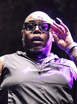 Headshot of Saucy Santana under harsh lighting against a dark background