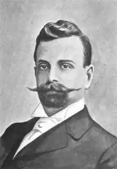 Man in a suit with a large moustache and goatee