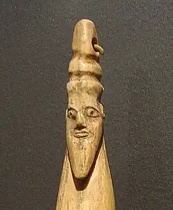 Hippopotamus tusk with carved head of a bearded man with torus-like headgear, Late Naqada I – Early Naqada II, 3800–3400 BC. Brooklyn Museum.[31]