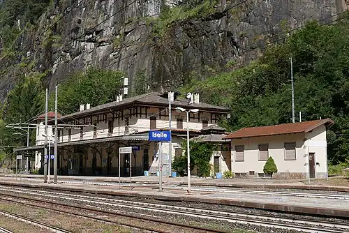 Station platforms in front of yellow two-story building with hip roof