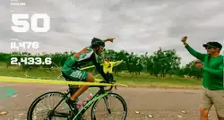 Jason Lester is wearing a black cycling helmet with overall and is mounted on a black bicycle