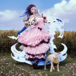 Jazmin Bean on a large white rocking horse in a grass field, with a lamb next to it