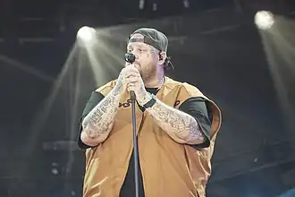 Jelly Roll holding a microphone onstage