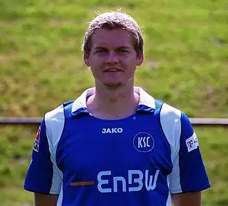 A young soccer player is standing in a field.