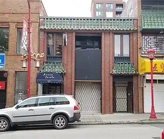 Facade of Kissa Tanto restaurant with a white car parked in front