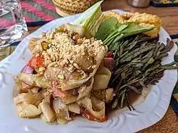 Lao-style green papaya salad (left) served with raw sprigs of water mimosa (right)