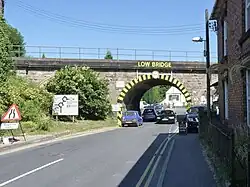 Large "low bridge" sign with hazard marking on the bridge
