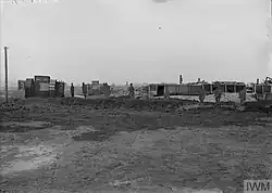 Cut outs that resemble British soldiers and tanks are arrayed across the center of the photograph.
