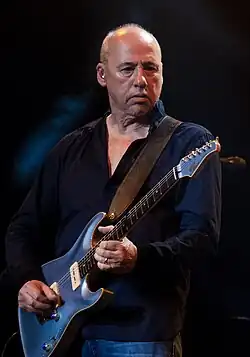 Mark Knopfler playing an electric guitar
