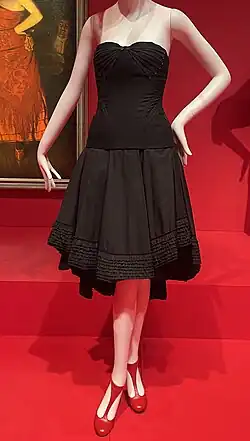 Mannqeuin wearing black mid-length dress and red shoes