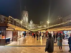 plaza night scene with christmas lights and stalls of vendors