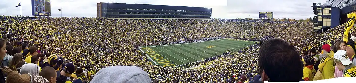 A stadium full of fans dressed in yellow, blue, and white.