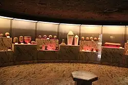 Multiple clay heads used as toppings for burial jars, each with a unique face