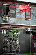 Monument on display at the entrance to the museum, with Chinese flag